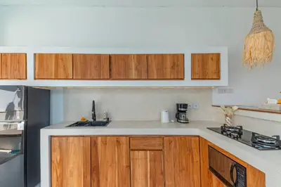 a kitchen with wooden cabinets and a white counter top at Villa MAVI Seminyak in Seminyak