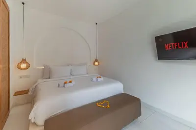 a bedroom with a white bed and a tv at Villa MAVI Seminyak in Seminyak