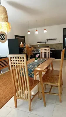 a dining room with a wooden table and chairs at 3 Bedroom Villa in Prime Seminyak Location, Walk to Beach in Seminyak