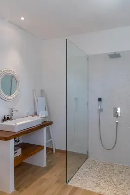 a bathroom with a glass shower and a sink at Wave - 6BR Luxe Canggu Villa with Rooftop & Pool in Canggu