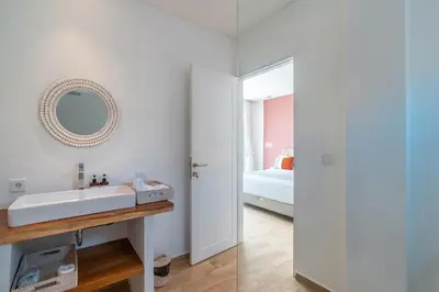 a white bathroom with a sink and a mirror at Wave - 6BR Luxe Canggu Villa with Rooftop & Pool in Canggu