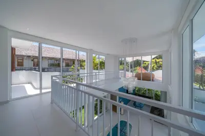 a white house with a balcony with a pool at Wave - 6BR Luxe Canggu Villa with Rooftop & Pool in Canggu