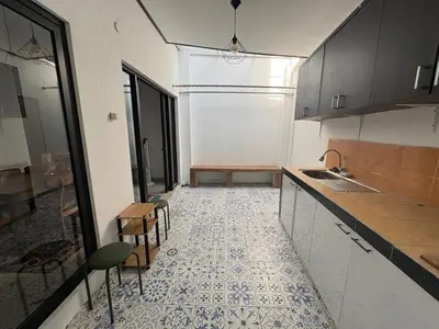a kitchen with a counter and a table and chairs at Villa Rumah Lemon Nusa Dua in Nusa Dua