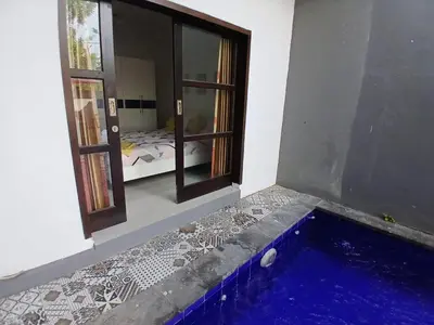 a room with a swimming pool and a room with a window at Villa Rumah Lemon Nusa Dua in Nusa Dua