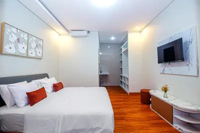 a bedroom with a white bed and a flat screen tv at The Hunian in Seminyak
