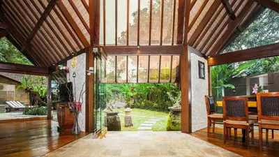 an open living room with a large glass door at Kalyca Seminyak 4 Bedroom in Seminyak