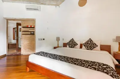 a bedroom with a large white bed in a room at Kalyca Seminyak 4 Bedroom in Seminyak