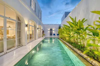 an indoor pool in a house with plants at Colonial Style 3BR Walking Distance to the Beach in Canggu