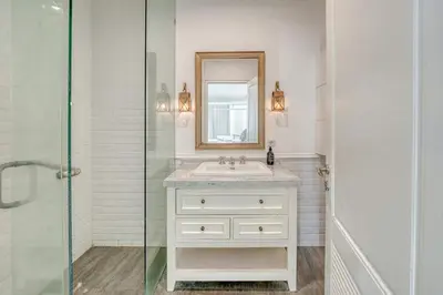 a white bathroom with a sink and a mirror at Colonial Style 3BR Walking Distance to the Beach in Canggu