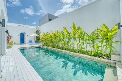 a swimming pool in the middle of a house at Colonial Style 3BR Walking Distance to the Beach in Canggu