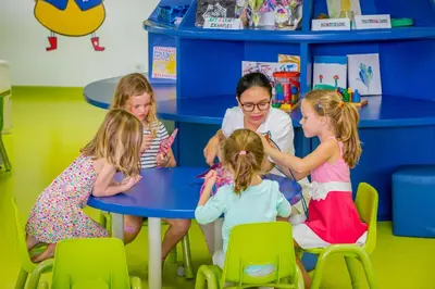 a group of children sitting at a table in a classroom at Montigo Resorts Seminyak in Seminyak