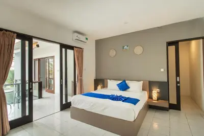 a bedroom with a large bed and a balcony at Taman Bali Villa Kerobokan 2 in Kerobokan