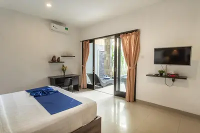 a bedroom with a bed and a tv and a balcony at Taman Bali Villa Kerobokan 2 in Kerobokan