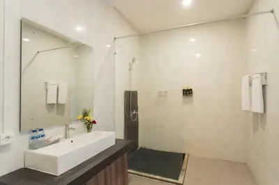 a bathroom with a sink and a shower with a mirror at Taman Bali Villa Kerobokan 2 in Kerobokan