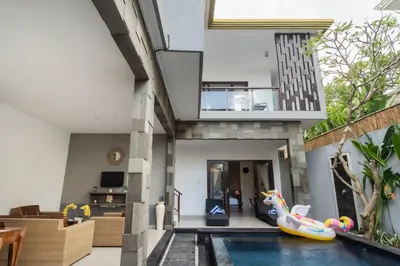 a house with an indoor swimming pool and a house with an inflatable at Taman Bali Villa Kerobokan 2 in Kerobokan