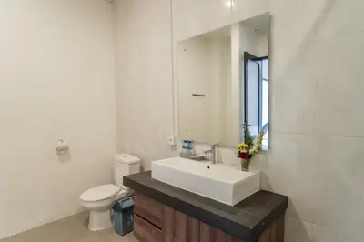a bathroom with a sink and a toilet and a mirror at Taman Bali Villa Kerobokan 2 in Kerobokan
