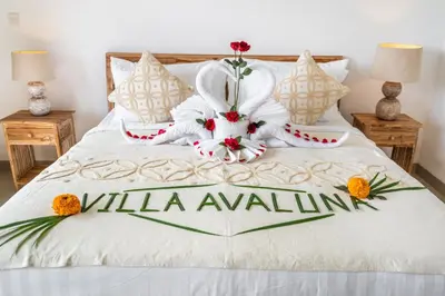 a white bed with a stuffed bunny on it at Villa Avaluna by JB Villas in Seminyak