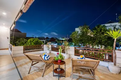 a balcony with chairs and a table with a view at Villa Avaluna by JB Villas in Seminyak