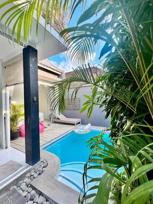 a pool in the backyard of a house with palm trees at Villa Marabia - Charming Quiet 3BR in Seminyak in Seminyak