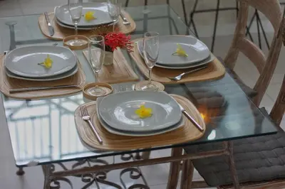 a glass table with plates and wine glasses on it at Villa Marabia - Charming Quiet 3BR in Seminyak in Seminyak
