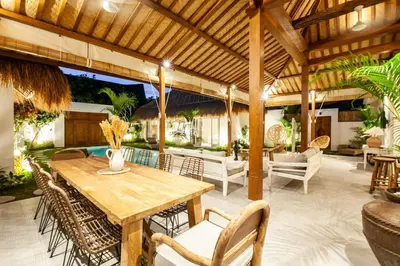 an outdoor patio with a wooden table and chairs at New 5 bedroom Villa close to Seminyak eat street in Seminyak