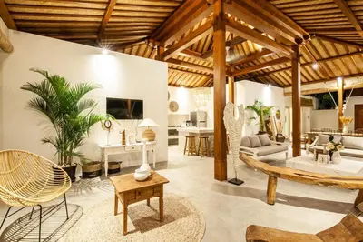 a living room with wooden ceilings and a living room with furniture at New 5 bedroom Villa close to Seminyak eat street in Seminyak