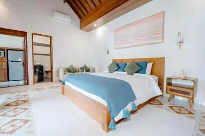 a bedroom with a large bed and a tv at Kania Rooms & Suite in Seminyak