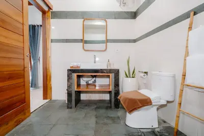 a bathroom with a sink and a toilet at Kania Rooms & Suite in Seminyak
