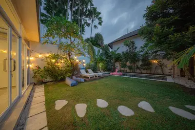 a backyard with a lawn with white rocks in the grass at Casa Sopi - Art Villa 2BR Near Batu Belig Beach in Seminyak