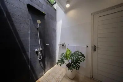 a bathroom with a potted plant and a shower at Casa Sopi - Art Villa 2BR Near Batu Belig Beach in Seminyak