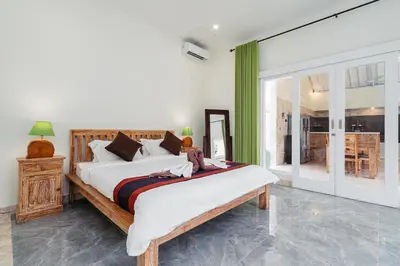 a bedroom with a large bed with a teddy bear on it at Green Garden Seminyak Villa in Seminyak