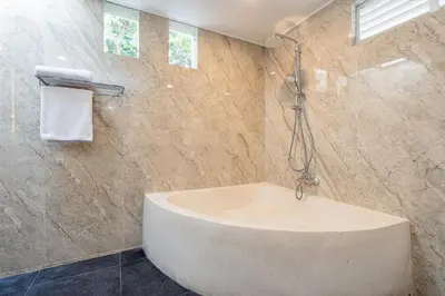 a bathroom with a bath tub and a shower at Green Garden Seminyak Villa in Seminyak