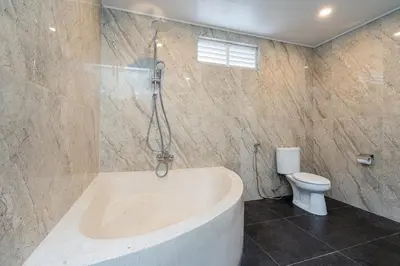 a bathroom with a tub and a toilet at Green Garden Seminyak Villa in Seminyak