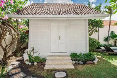 a small white shed with stairs in a yard at Green Garden Seminyak Villa in Seminyak