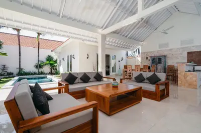a living room with couches and a table and a pool at Green Garden Seminyak Villa in Seminyak