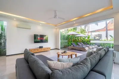 a living room with a large couch and a tv at Villa Aquila in Seminyak