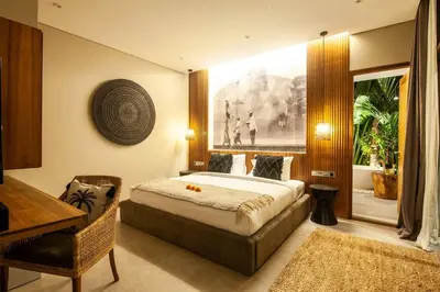 a bedroom with a bed and a table and a desk at Luxury 6BR villa Berawa beach in Canggu