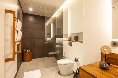 a bathroom with a toilet and a shower at Luxury 6BR villa Berawa beach in Canggu