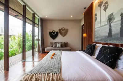 a bedroom with a large bed and large windows at Luxury 6BR villa Berawa beach in Canggu