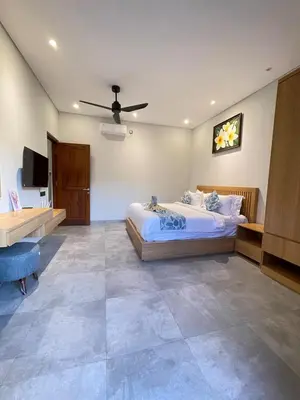 a bedroom with a bed and a ceiling fan at Villa in South Kuta Dewi Amerta villa in Jimbaran