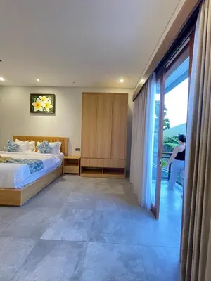 a bedroom with a bed and a sliding glass door at Villa in South Kuta Dewi Amerta villa in Jimbaran