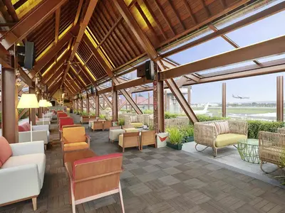 a large lobby with couches and tables and chairs at Novotel Bali Ngurah Rai Airport in Kuta
