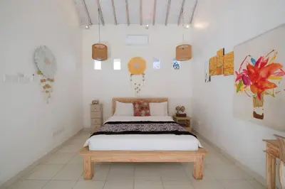 a bedroom with a bed and a wooden bench at Beji Ayu Seminyak - 1 Bedroom Private Villa in Seminyak