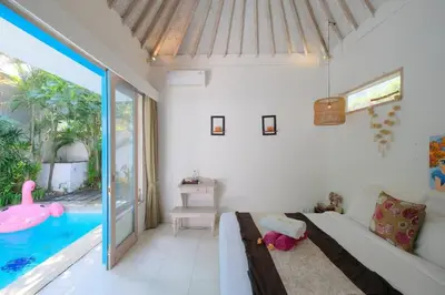a bedroom with a bed and a swimming pool at Beji Ayu Seminyak - 1 Bedroom Private Villa in Seminyak