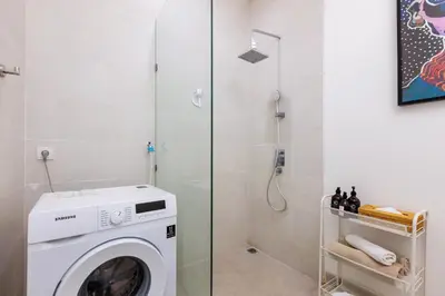 a washing machine in a bathroom with a shower at CS 2 Luxurious 3 BR New Villa Near Double Six Beach in Seminyak