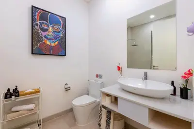 a bathroom with a sink and a painting on the wall at CS 2 Luxurious 3 BR New Villa Near Double Six Beach in Seminyak