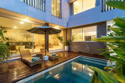 a house with a swimming pool and an umbrella at CS 2 Luxurious 3 BR New Villa Near Double Six Beach in Seminyak