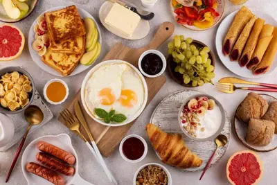 a table full of breakfast food with eggs and bread at CS 2 Luxurious 3 BR New Villa Near Double Six Beach in Seminyak