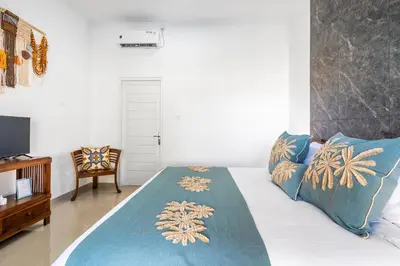 a bedroom with a bed with a blue blanket on it at RK3, 2 beds villa 15 min walk to Double Six Beach in Seminyak