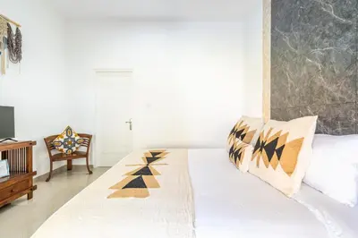 a bedroom with a bed and a chair at RK3, 2 beds villa 15 min walk to Double Six Beach in Seminyak
